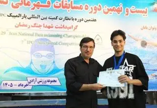 اهدا نشان مسابقات پاراشنا به شناگر جانباز جنگ رمضان